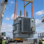 Transformer lift using a spreader beam and four-leg sling